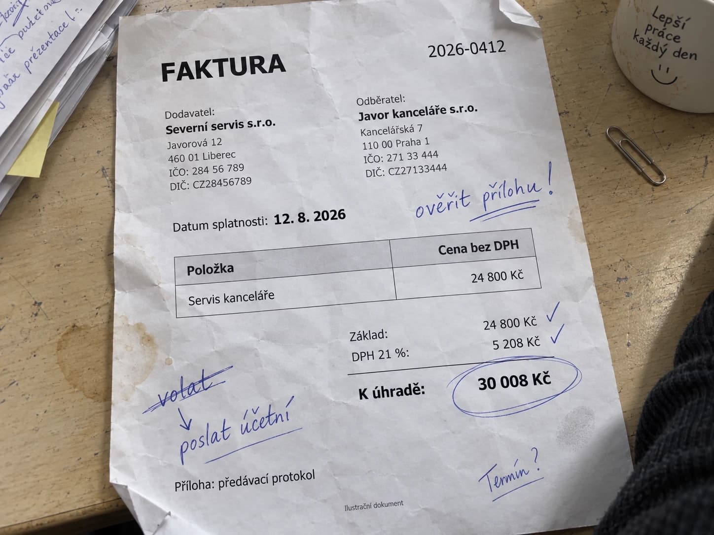 Pomačkaná faktura vyfocená nakřivo na stole, s ručními poznámkami a zakroužkovanou částkou